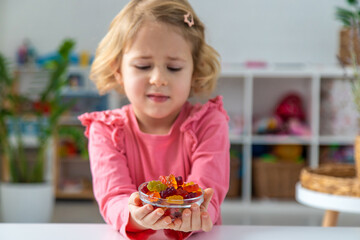 Child eating jelly candies at home. Selective focus.