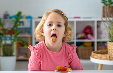 Child eating jelly candies at home. Selective focus.
