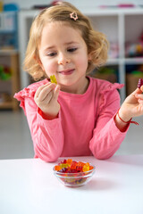 Child eating jelly candies at home. Selective focus.