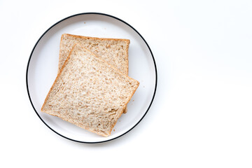 Whole wheat bread on plate. Healthy slices, simple food. Top-down view, white background, clean presentation.