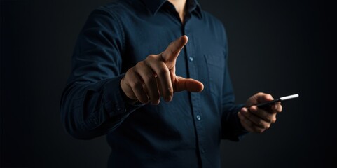 Man points forward while holding smartphone against dark background in tech interaction pose