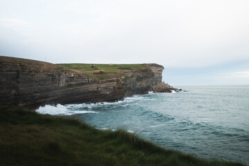 Coastline with cliffs and grass fields in northern Spain.