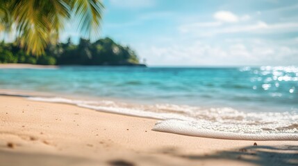 Tropical beach background with white sand and palm leaves, blurred ocean in the distance. Summer vacation concept