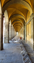 una bicicletta bianca nei portici deserti di Lucca