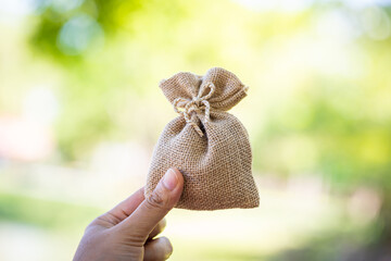 Women hand hold money bag for select or give a loaning in the public park, Loan to planned the...
