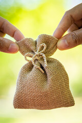 Businessman and women hand hold money bag for select or give a loaning in the public park, Loan to...