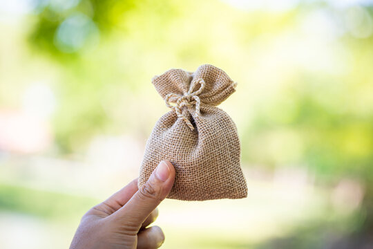 Women hand hold money bag for select or give a loaning in the public park, Loan to planned the business investment in the future concept.