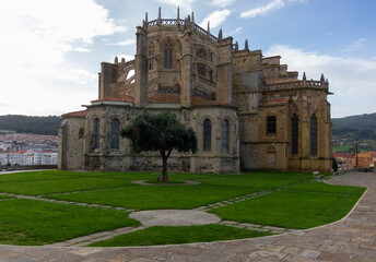 Fototapeta premium Detail plan of the impressive church of Santa María de la Asunción located in the touristic village of Cantabria by the sea and surrounded by trees.