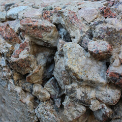 Part of rough concrete basement with mixed granite stones square stock photo 
