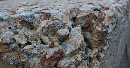 Cement wall made with hardened cement mortar. Large fraction gravel stones hardened in concrete