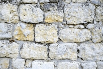 Fototapeta premium Rustic limestone wall close-up with earthy tones. AI image