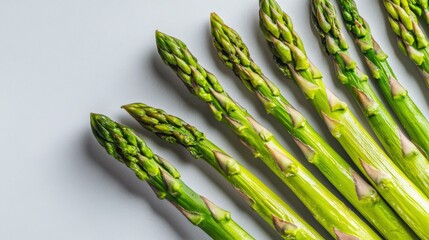 Organic green asparagus spears artistically arranged on a soft gray background