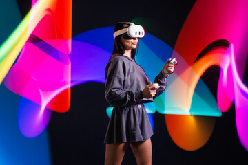 Young woman in VR headset playing virtual reality game with motion controllers, neon light trails in futuristic immersive environment.