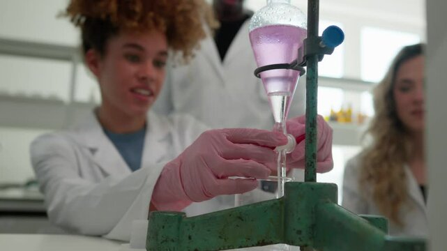 Young scientists carefully perform a titration, adding a pink solution to a flask using a burette, demonstrating precision and focus in their scientific investigation