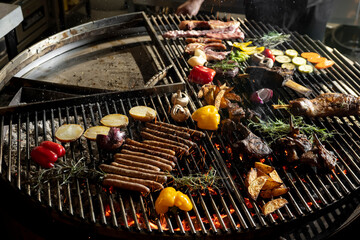 roasted meat and vegetables on the grill with flames and vegetables, close up