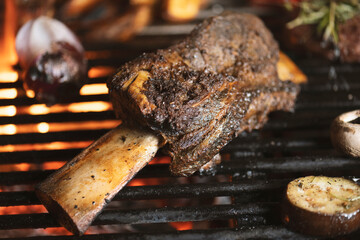 roasted meat and vegetables on the grill with flames and vegetables, close up