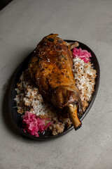 Leg of lamb with rice and red onion on gray background