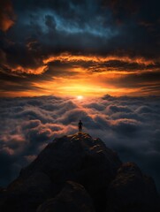 Silhouette on a summit, overlooking a dramatic cloudscape at sunset
