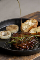Pan-fried steak with toast and rosemary, drizzled with olive oil