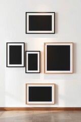 Arrangement of picture frames on a white wall in a gallery with wooden trim and a grey tile floor.