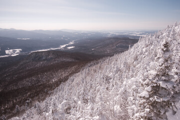 view from the top of a snow-covered mountain, of landscapes, mountains and rivers in the distance