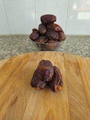 Dates in a bowl on a wooden background. Dried fruits. Dried date fruit. PNG, Ramadan. Organic dried medium fruit snack. Dried date palm.