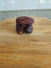Dates in a bowl on a wooden background. Dried fruits. Dried date fruit. PNG, Ramadan. Organic dried medium fruit snack. Dried date palm.