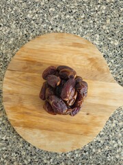 Dates in a bowl on a wooden background. Dried fruits. Dried date fruit. PNG, Ramadan. Organic dried medium fruit snack. Dried date palm.