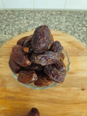 Dates in a bowl on a wooden background. Dried fruits. Dried date fruit. PNG, Ramadan. Organic dried medium fruit snack. Dried date palm.