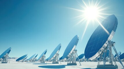 Array of satellite dishes under bright sun in a snowy landscape.
