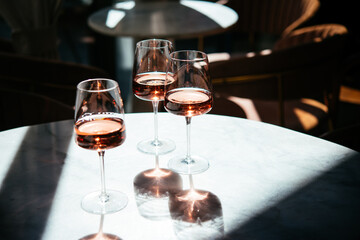 Glasses of rose wine seen in summer sunshine during a wine tasting in a bar or restaurant.