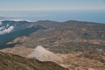 Stunning panoramic view of volcanic landscape with clouds, revealing a vast, rugged terrain under a...