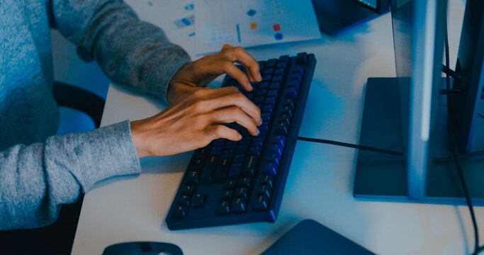 Closeup young adult Asia male freelance typing write prompt AI bot IT app smart program nomad, video game, terminal with coding language, designer, big data center on desktop computer in night office.