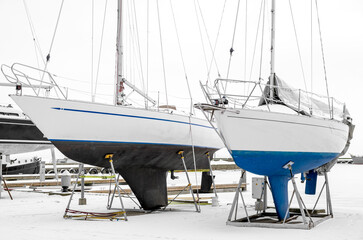 Fototapeta premium Modern yachts dry docked at frozen boat marina in winter