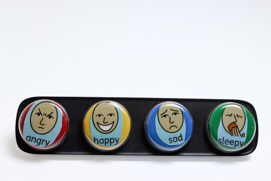 communication aid, set of four coloured switches to help non verbal people indicate emotions, happy, sad, sleepy or angry. on a white background with room for text