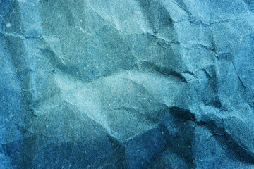 Background of blue textured paper with crumples. Poster or sticker with pattern