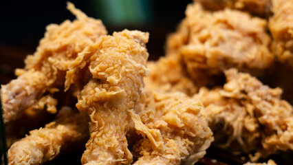 Close-up of hot, freshly fried chicken with a crispy golden texture, served at a street vendor's stall. The crunchy batter enhances its rich flavor