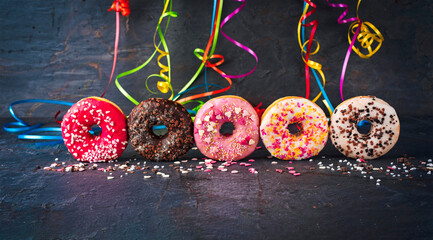 Traditional festive glazed with icing sugar and chocolate doughnuts decorated with colorful...