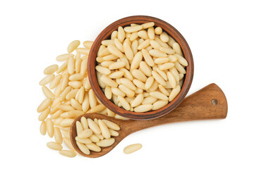 Shelled European pine nuts in ceramic bowl and wooden spoon isolated on white background. Top view....