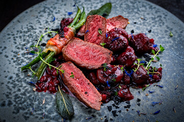 Traditionally roasted fillet of saddle of venison with chestnuts, bacon-wrapped bean sticks and...