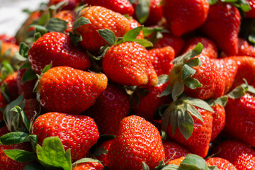 Piles of fresh strawberries for sale at the market.