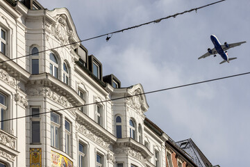 A passenger plane flying over the tenement houses on the Maria Theresa Street, Innsbruck, Austria