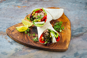 Italian style Wrap Piada wheat Tortilla with tuna fish, corn, vegetable salad and hard boiled egg seried on tray