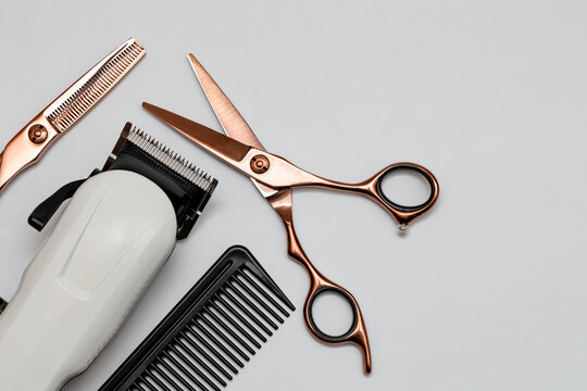 Hairdressing and barber tools. Professional scissors, hairdressing clipper and comb. White background.
