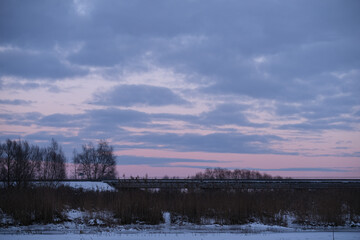 Winter landscape with a frozen lake and dry grass. 