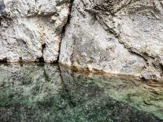 close-up of gorge cliff reflecting in the calm waters of mountain river. clean transparent mountain river. natural mountain pool