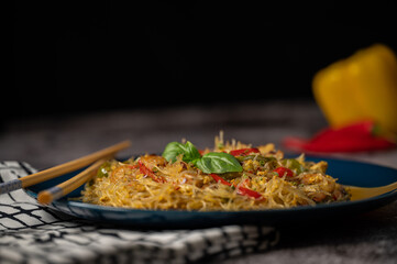 Asian salad with glass noodles, chicken, prawn, shrimp and vegetables on a gray background .