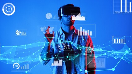 Skilled business man wearing VR glasses and casual cloth while looking at financial chart. Project manager working and checking at statistic graph holographic while connecting metaverse. Apparatus.