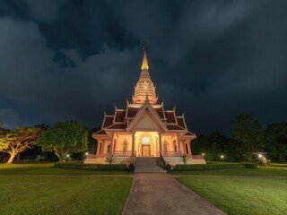 Naklejka premium Wat Pa Phu Kon, a serene Buddhist temple located in Udon Thani, Thailand, illuminated by the glow of moving clouds in the night sky, night sky, Thailand, Udon Thani