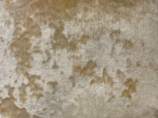 Close up of decorative satin gold and brass fabric in random grunge and dirt texture. Golden fabric seamless background texture.